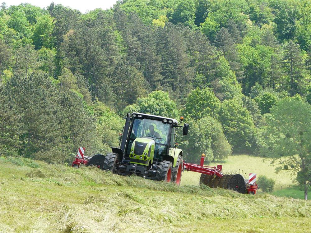 Tracteur avec faneuse dans un champ