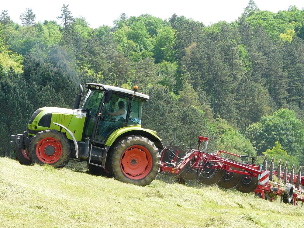 Tracteur vert labourant un champ