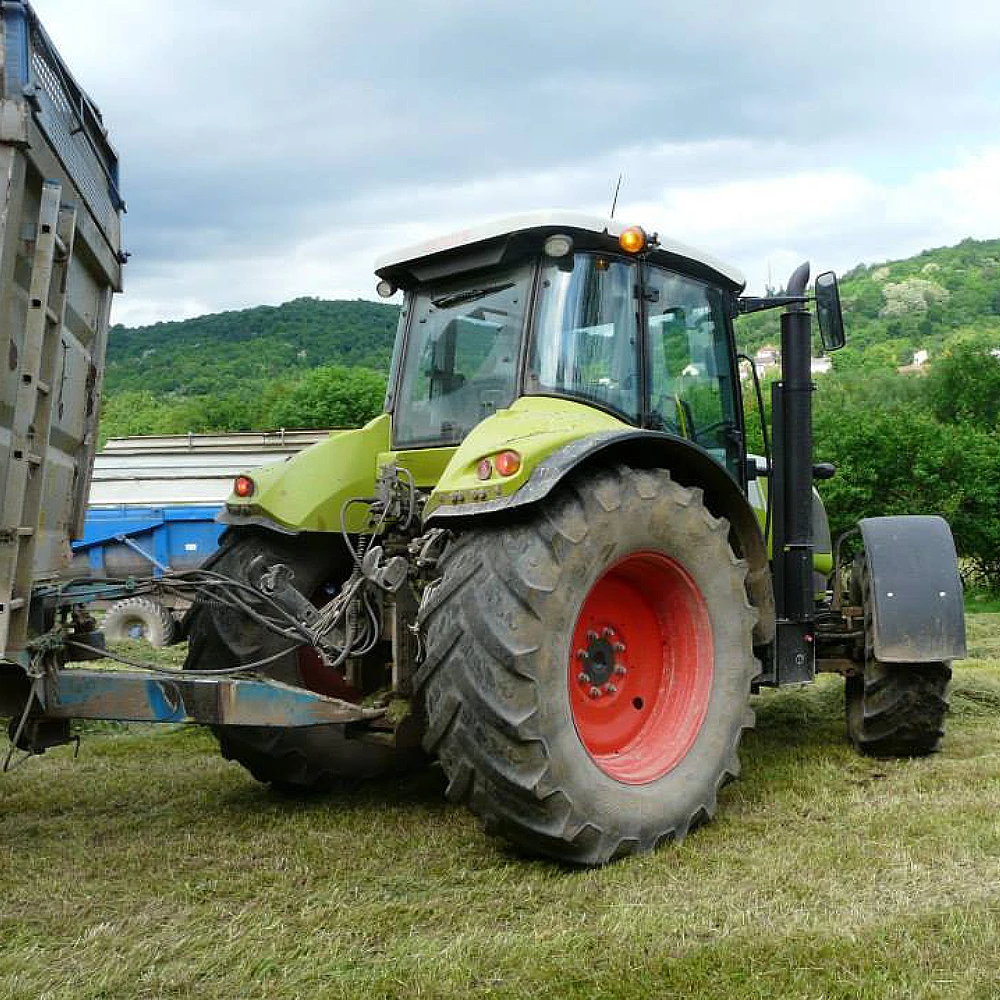 Tracteur vert avec remorque dans un champ